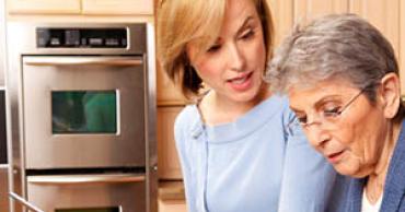 A caregiver helping a woman find online resources